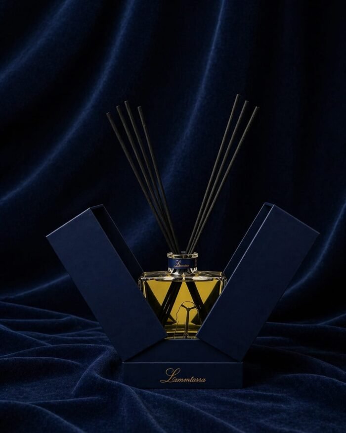 Lammtarra reed diffuser with amber fragrance and black reeds in the open navy gift box on navy velvet